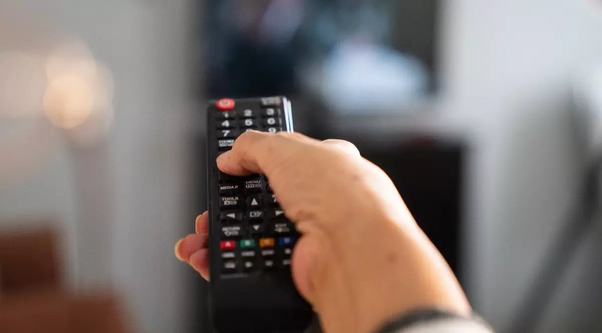 O femeie care ține o telecomandă în mână