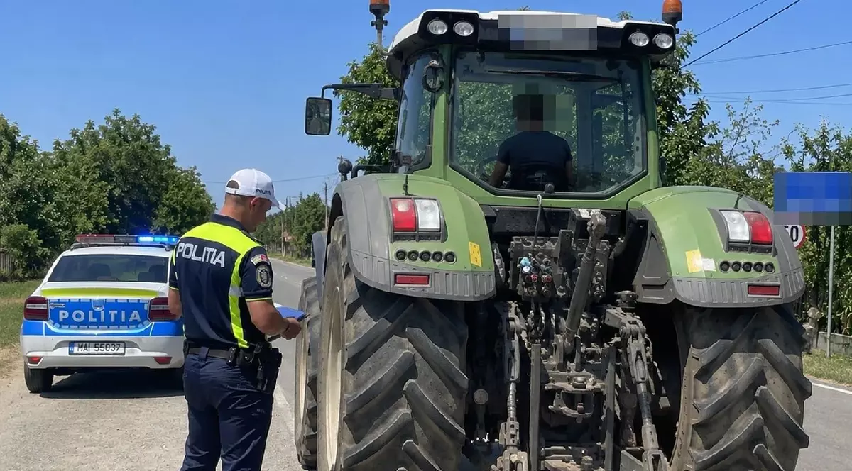 Un tractor verde tras pe dreapta de un polițist
