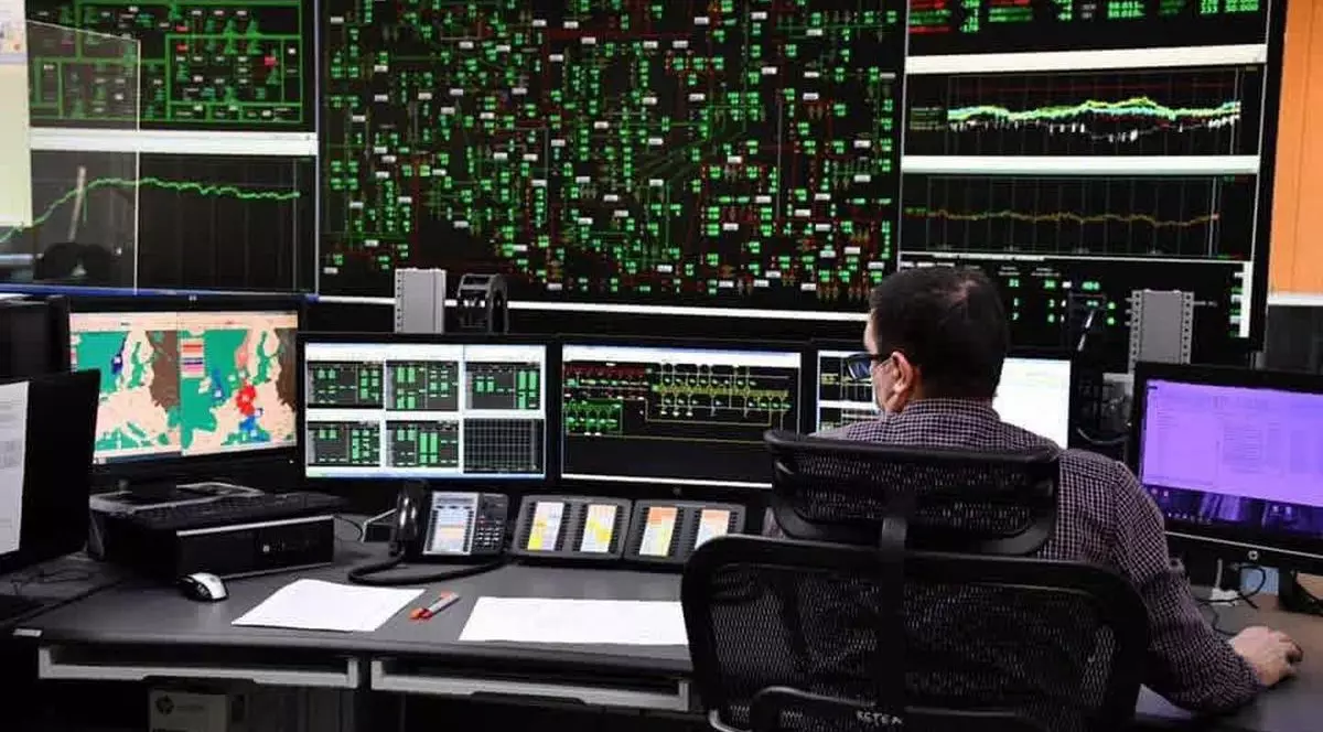 Un angajat Transelectrica este la birou se uită pe monitoare pentru a vedea consumul de energie