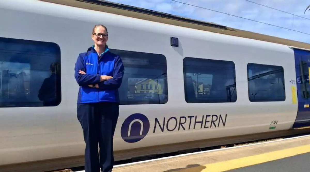 Alex Worsick , fosta jurnalista BBC, pe peron in fata unui tren pe care scrie NORTHERN