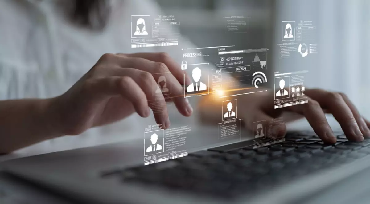 Cum afli ce date există despre tine pe internet și cum le ștergi - Imagine cu un bărbat in faţa unei tastaturi deaspra căreia se află un ecran virtual care sugerează datele personale ale unor persoane