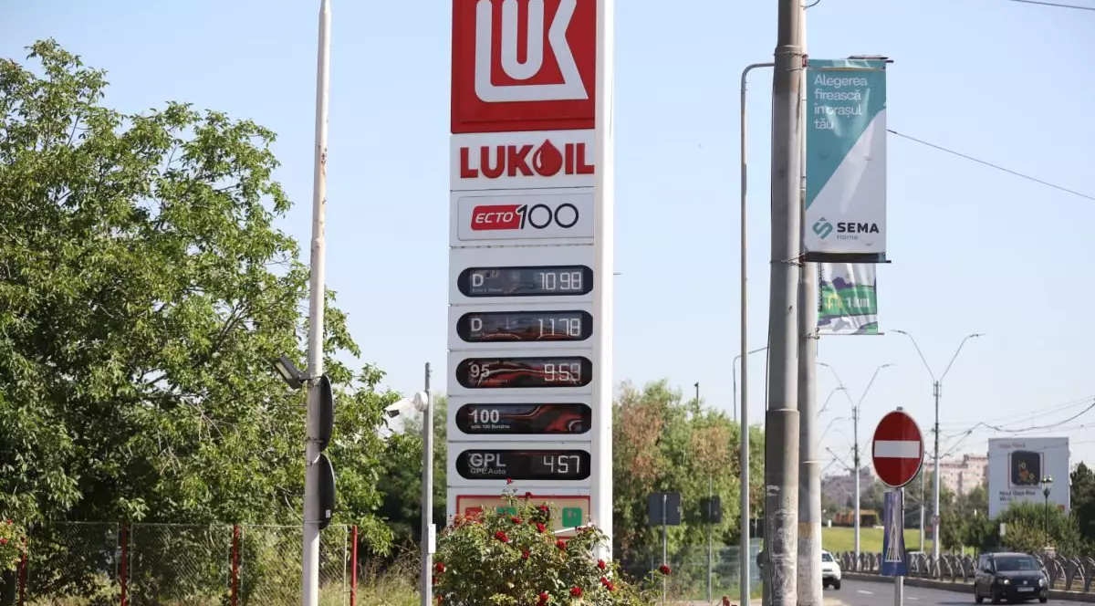 O benzinărie Lukoil care are prețurile afișate, iar în dreapta se vede o mașină mergând pe stradă, în București, 4 august 2026