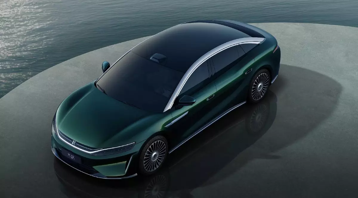 Imaginea prezintă un sedan BYD de culoare verde-închis, parcat pe o platformă circulară