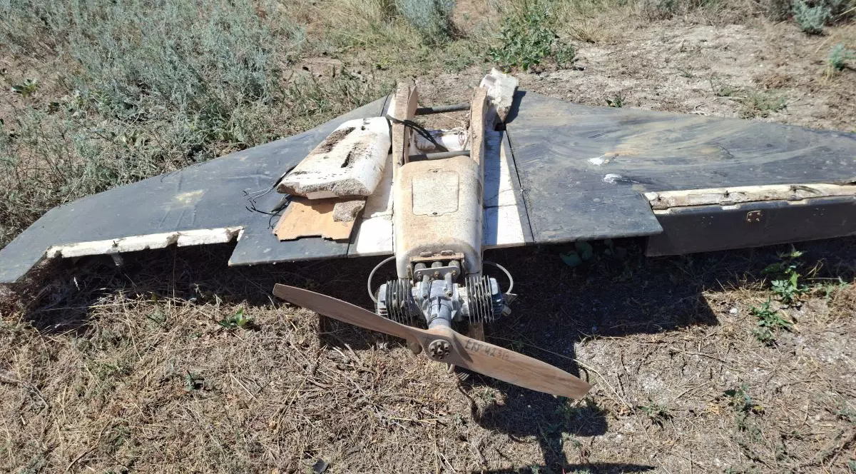 Dronă aeriană, prăbușită pe un câmp, avariată, dar cu elicea și motorul încă atașate de corpul aeronavei