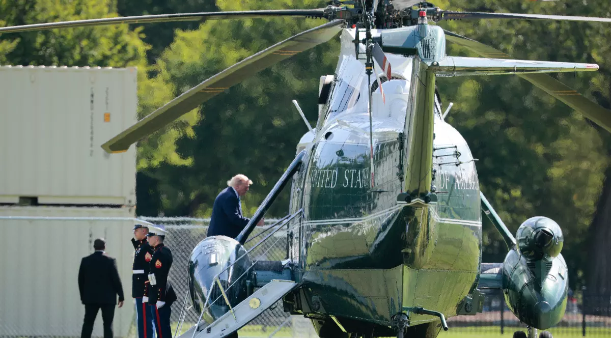 Imaginea îl prezintă pe Donald Trump urcând la bordul elicopterului prezidențial Marine One, în timp ce militari din Marina SUA îi salută.