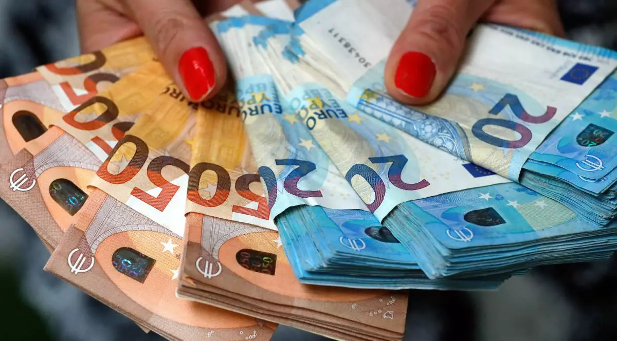 Femeie care ține bancnote și bancnote euro