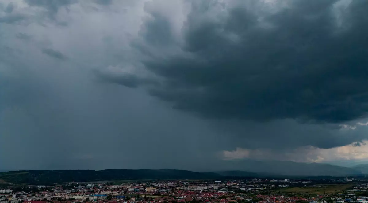 Imaginea înfățișează nori negri și întunecați de furtună deasupra unui oraș