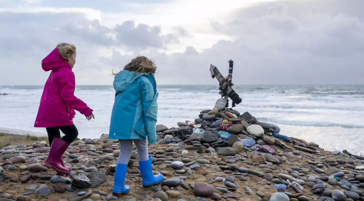 Copii privesc un „mormânt” dedicat lui Dobby – un elf de casă fictiv din romanele și filmele fantastice *Harry Potter* – pe plaja Freshwater West din Castlemartin, Regatul Unit, la 6 noiembrie 2022