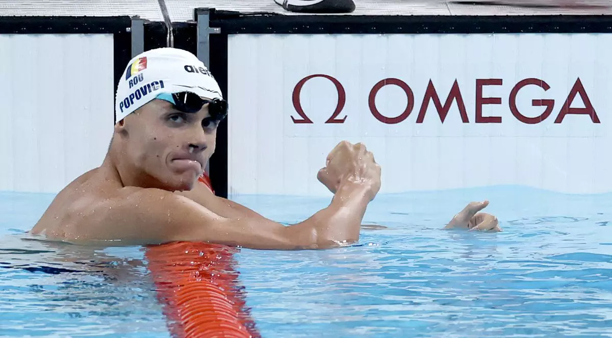 sărbătorește după câștigarea medaliei de aur în finala probei masculine de 200 m liber, în a treia zi a Jocurilor Olimpice de la Paris 2024, la Paris La Défense Arena, pe 29 iulie 2024, în Nanterre, Franța