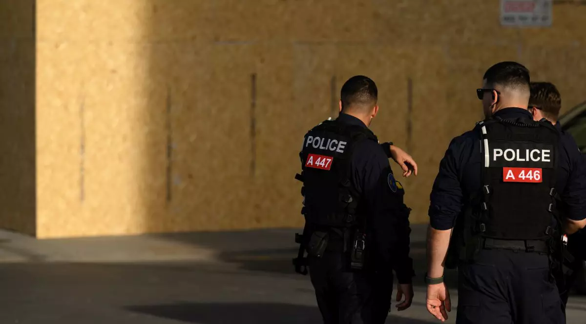 Polițiști patrulează lângă o clădire protejată cu panouri din lemn, montate în anticiparea protestelor legate de summitul G7 care urmează să aibă loc în apropiere, la Evian, pe 13 iunie 2026, la Geneva, în Elveția