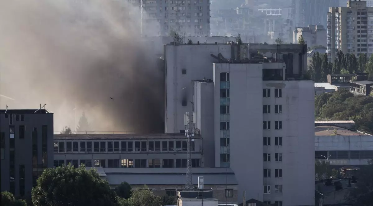 Un fum gros se ridică dintre mai multe clădiri înalte din Kiev, în urma unui atac aerian rusesc, 19 iulie 2026