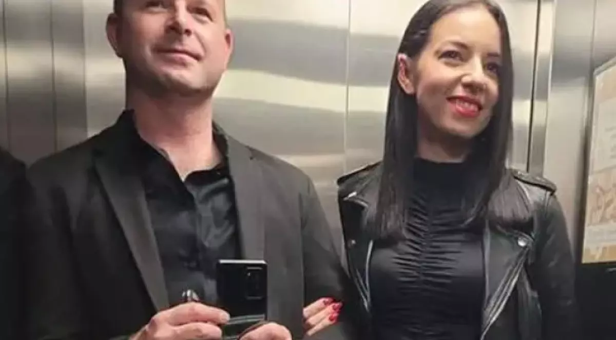 Josip și Monika Sincek, foografiați într-un lift, zâmbind. Bărbatul are un smarphone în mâini