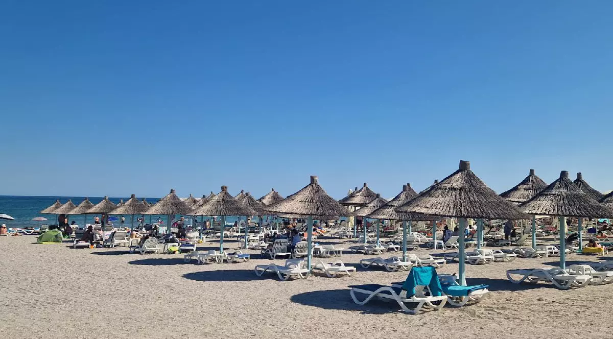 Umbrelute de paie si sezlonguri pe plaja la mare. Litoralul romanesc.