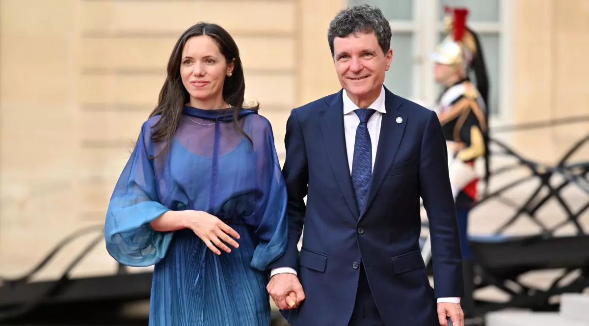 Mirabela Grădinaru, îmbrăcată cu o rochie albastră, și Nicușor Dan, îmbrăcat cu un costum negru, cămașă albă și cravată albastră, pe 13 iulie 2026, la Palatul Elysee din Paris