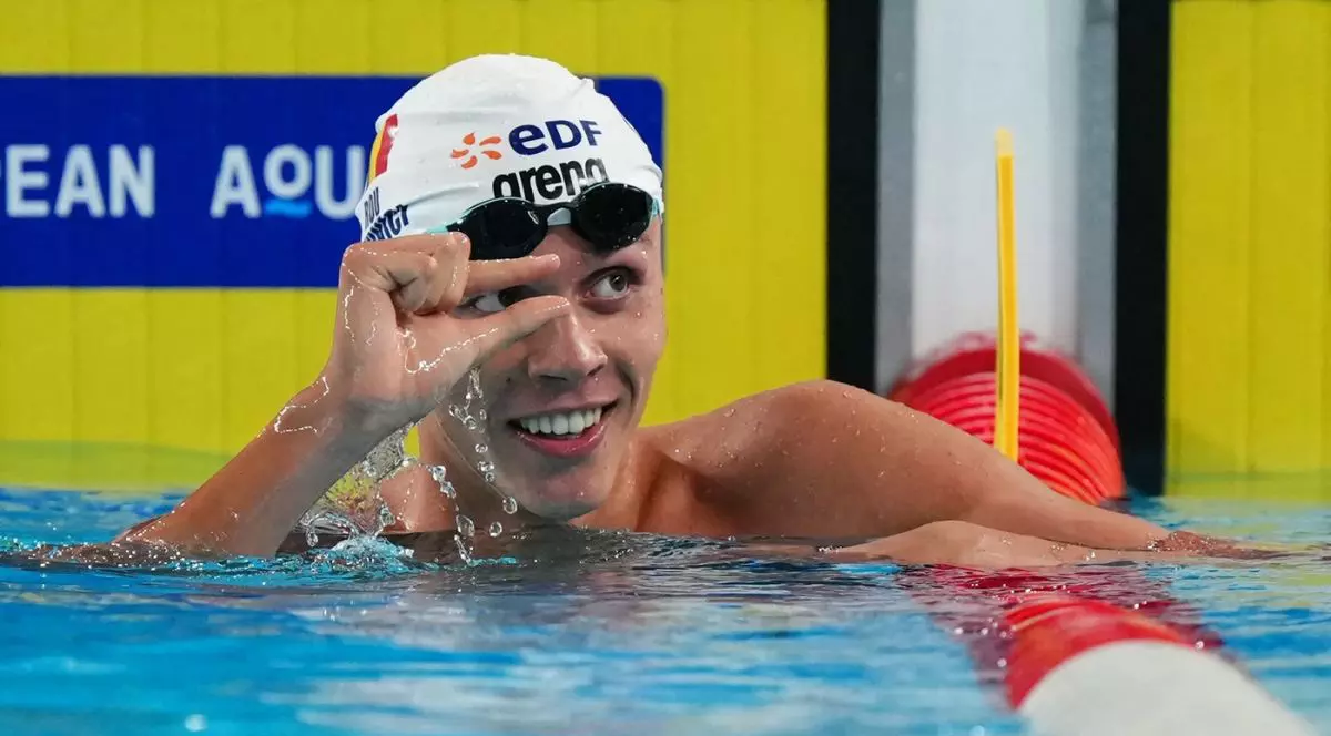 David Popovici face un semn cu mâna, arătând cât de mică a fost diferența dintre el și cel de-al doilea clasat în finala probei de 100 de metri de la CAmpionatul European de la Paris, 12 august 2026