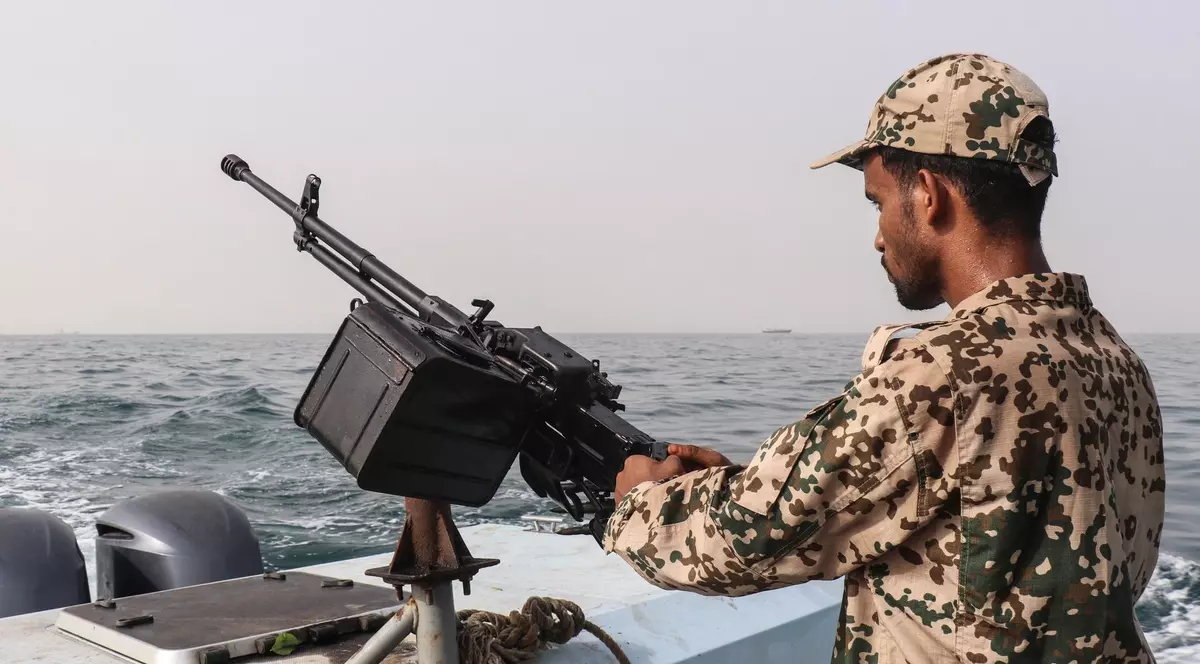 Un soldat al Guvernului din Yemen recunoscut pe plan internațional surprins în timp ce ține o mitralieră în timpul unei misiuni de patrulare în largul insulei Hanish Foto: Profimedia