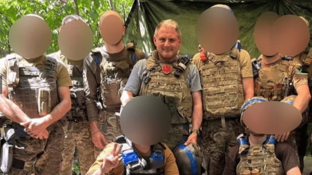 Jack Lopresti, central, fata neblurata, in mijlocul unor luptători din Legiunea Internațională care luptă în Ucraina