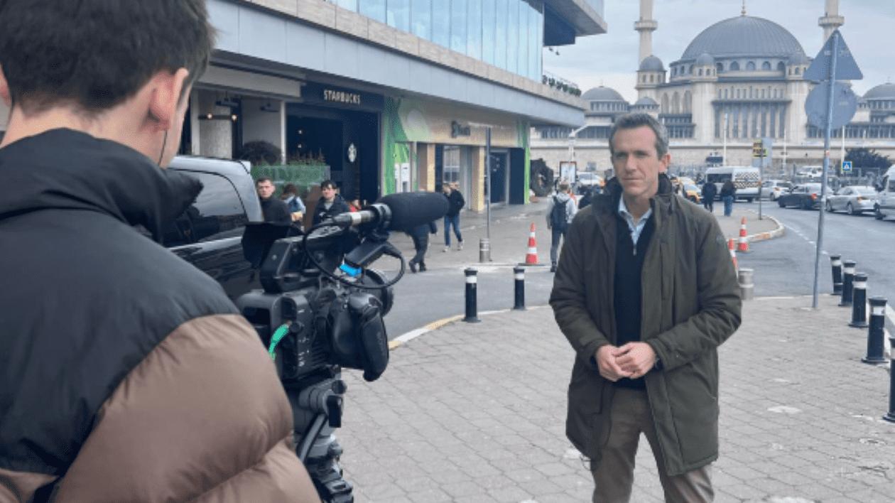 Mark Lowen surprins în timp ce stă în fața unui tânăr care are o cameră video
