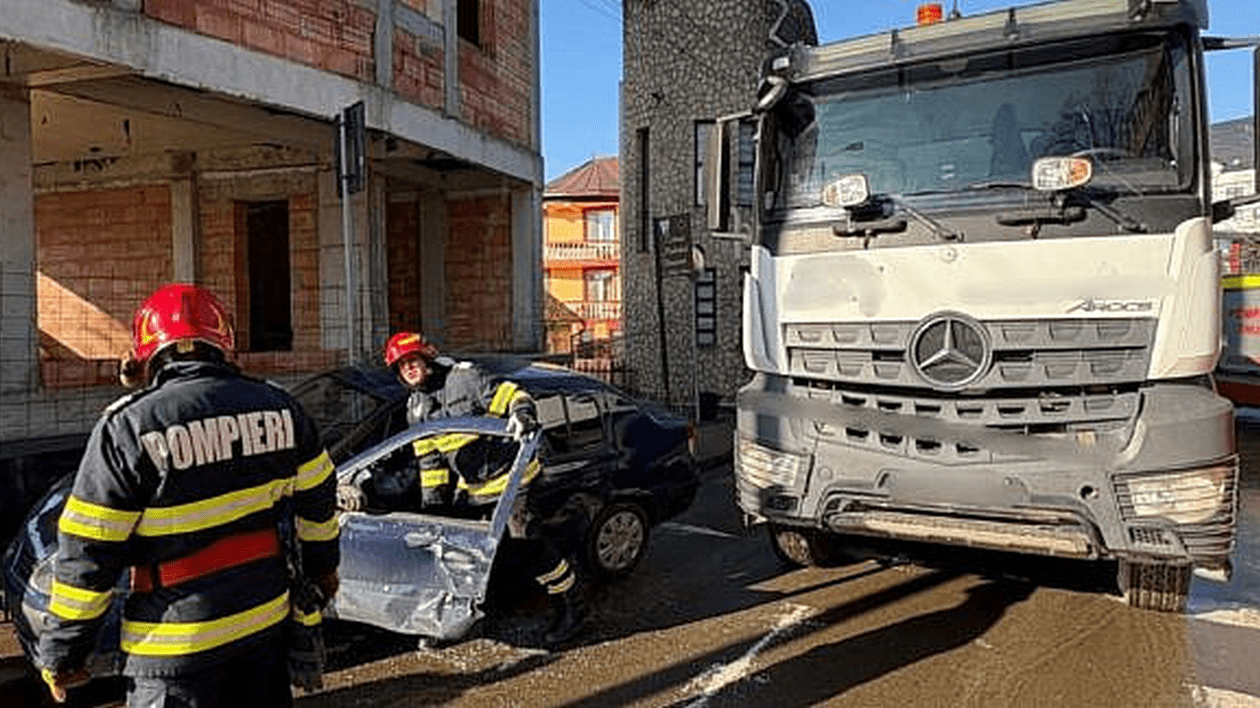 Momentul în care o basculantă agață un Logan și pleacă cu el. Șoferița autoturismului a trebuit să fie descarcerată | VIDEO
