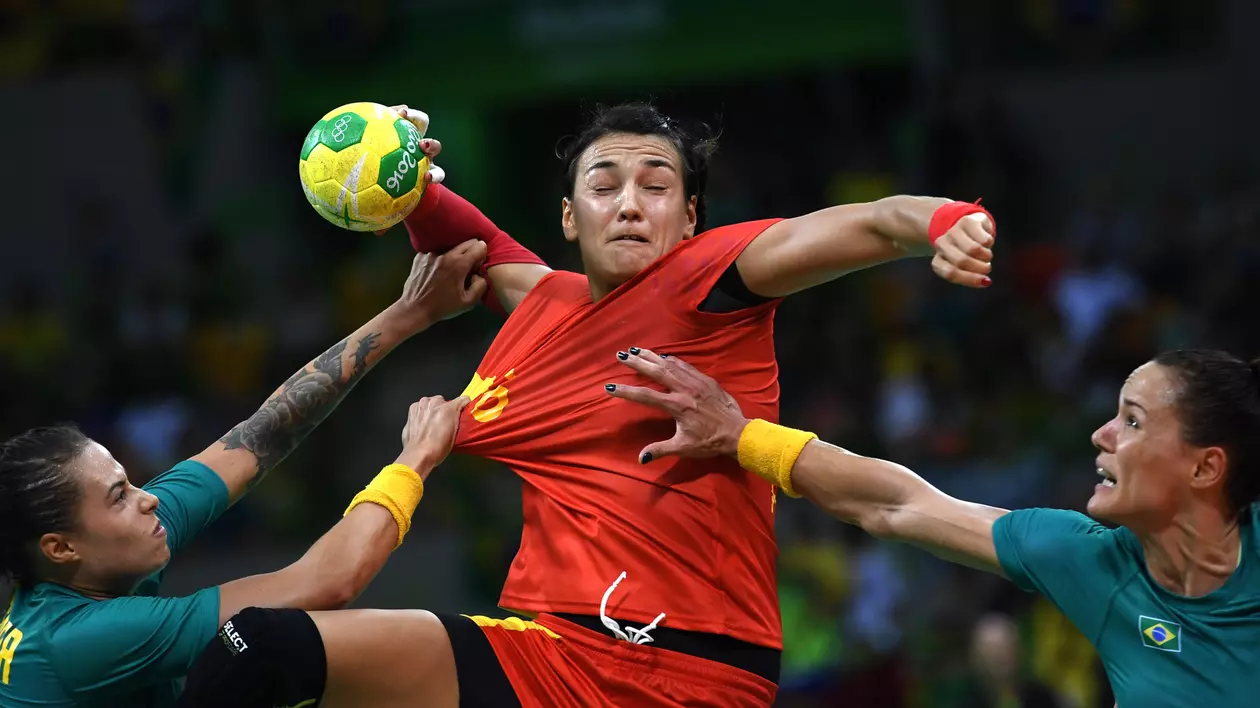 Cristina Neagu se înalță deasupra barajului format de brațele a două adversare și se pregătește să tragă la poartă. (FOTO: EPA)