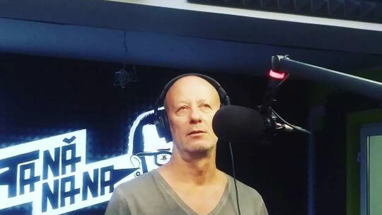 Andrei Gheorghe, cu căștile pe urechi, vorbește la microfon, într-un studio radio