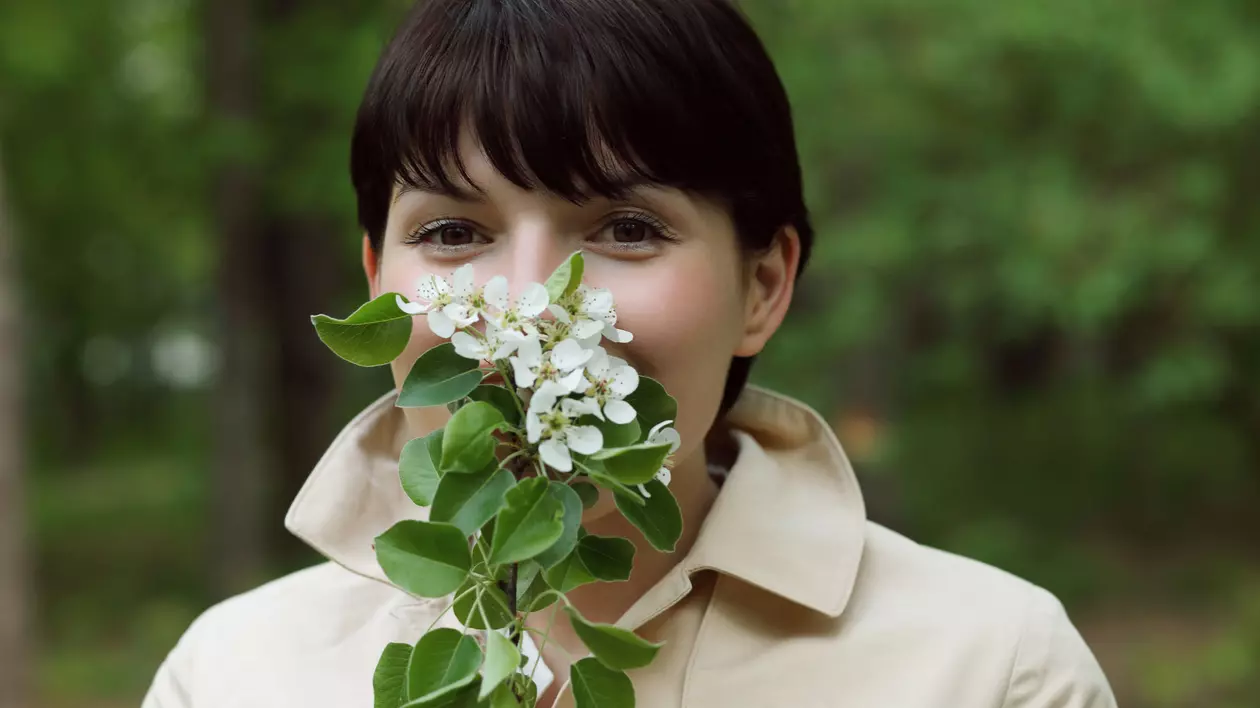 Mesaje de 8 martie- Femeie care miroase un buchet de lăcărmioare