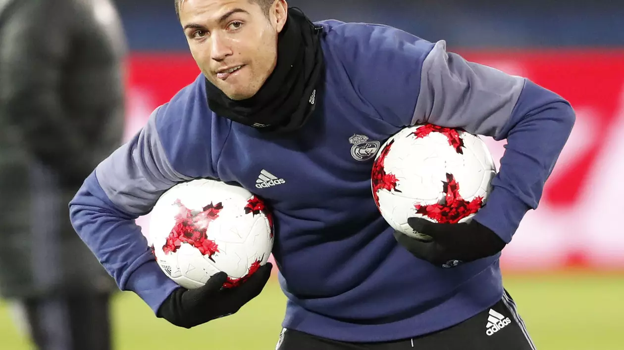 Cristiano Ronaldo, purtând în braţe două mingi de fotbal în timpul unui antrenament al lui Real Madrid. (FOTO: HEPTA)