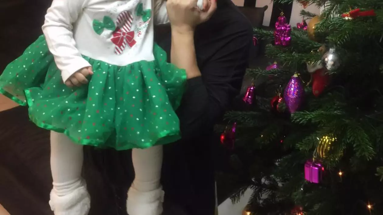 Anda Adam o sărută pe fiica, Evelin, lângă bradul de Crăciun