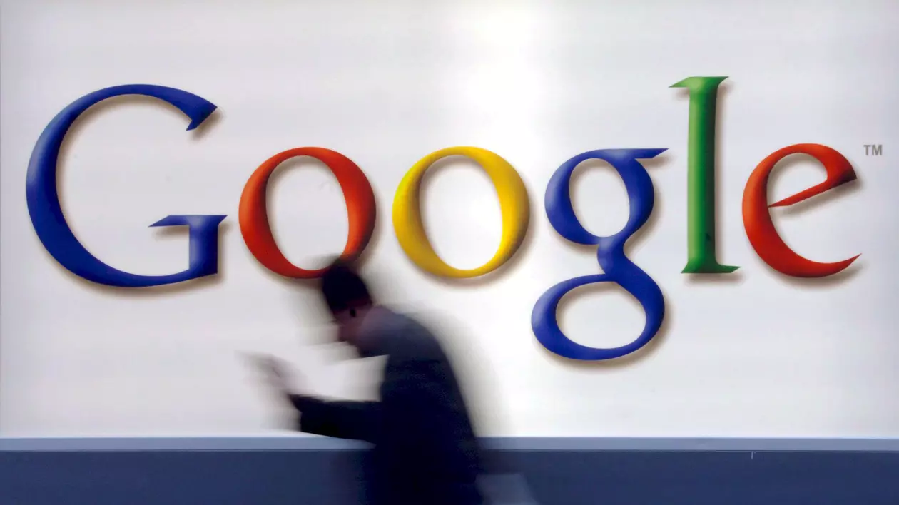 Google, reclamată din nou la Comisia Europeană de rivali online. Logo-ul Google prin fața căruia trece un om