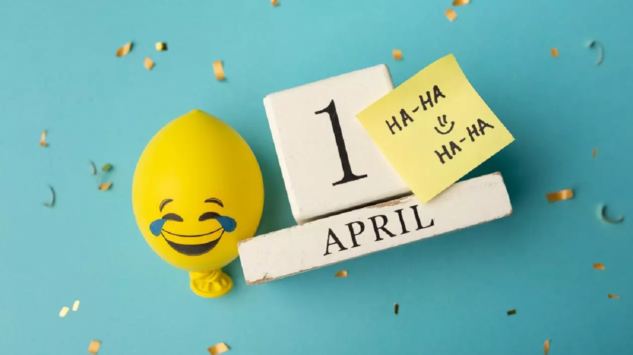 Data de 1 aprilie scrisa pe fundal bleu, lângă un balon galben cu emoticon amuzant si un bilețel pe care scrie Ha-ha