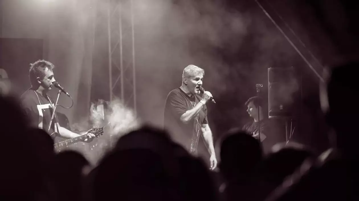 Trupa Holograf donează banii primiți pentru spectacolul din Sectorul 5. Fotografie alb-negru din timpul unui concert al trupei Holograf, cu Dan Bittman la microfon