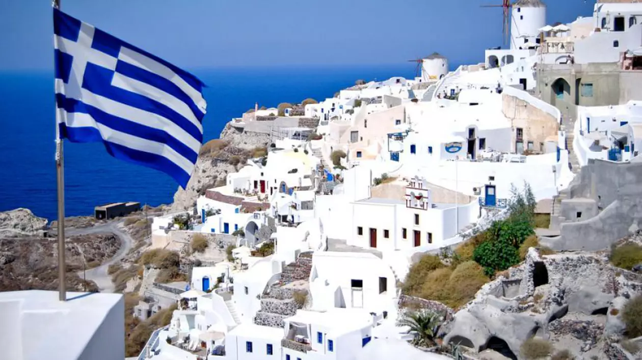 Majorări salariale în Grecia. Peisaj din Grecia, cu un drapel al acestei țări fluturând