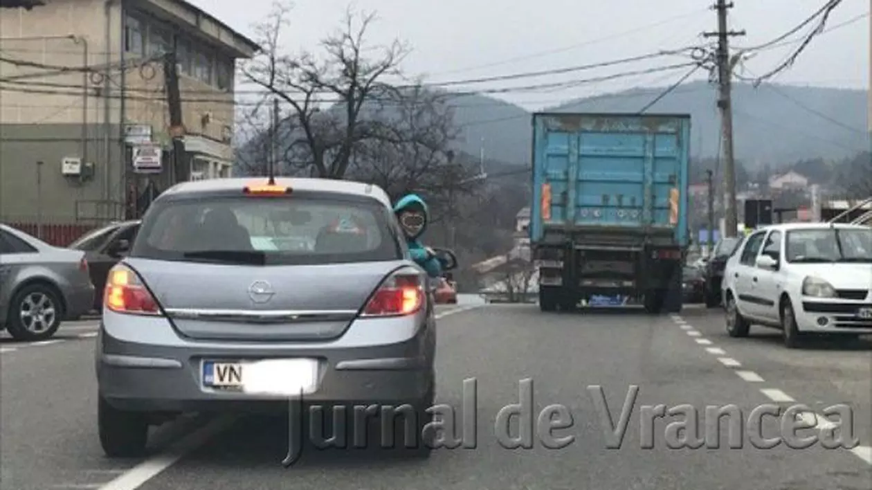 Un copil ieșit pe geamul din spate al unei mașini, surprins în Vrancea. Șoferul nu a ținut cont de claxoane. Imagini revoltătoare