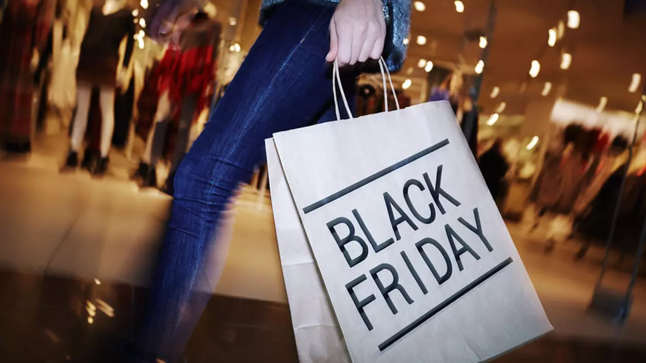 Black Friday are loc anul acesta pe 13 noiembrie. Tânără cu o pungă de cumpărături pe care scrie Black Friday