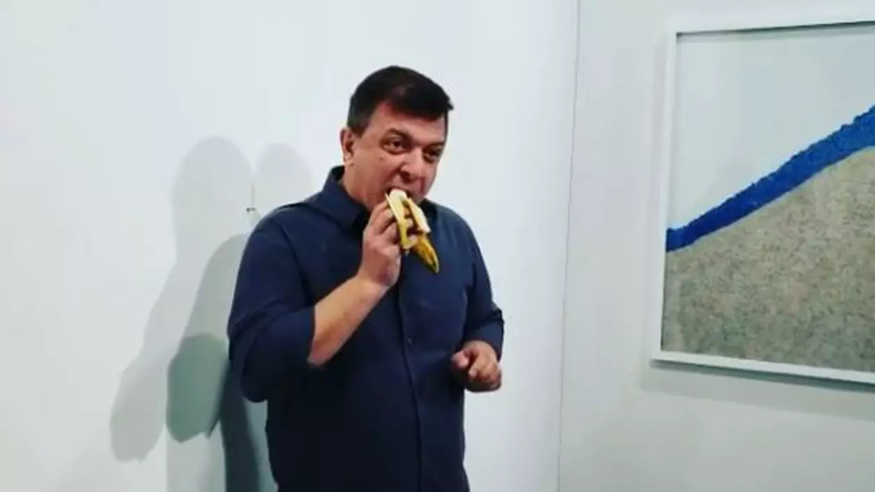 VIDEO | Banana lipită cu bandă adezivă pe un perete și vândută cu 120.000 de dolari, mâncată de un "Artist Flămând": "Ador această instalaţie. E foarte delicioasă"