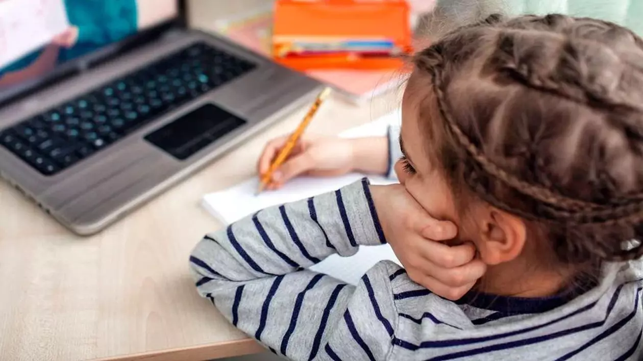 Cele mai bune laptopuri și tablete pentru începerea școlii. La ce trebuie să fim atenți când cumpărăm un astfel de dispozitiv. Fetiță în fața unui laptop, uitându-se la o transmisie video