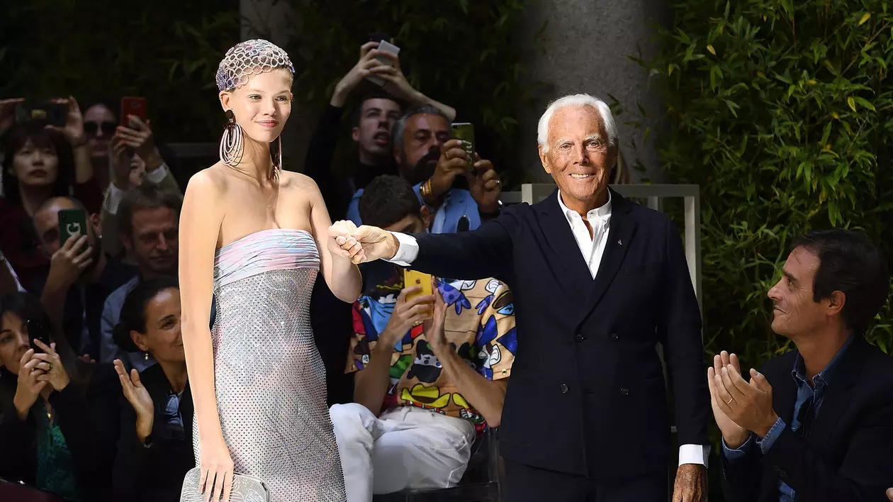 Giorgio Armani, pe catwalk, alături de un model, la sfârșitul prezentării propriei colecții pentru sezonul primăvară-vară 2020, în septembrie 2019, la Milano. FOTO: EPA