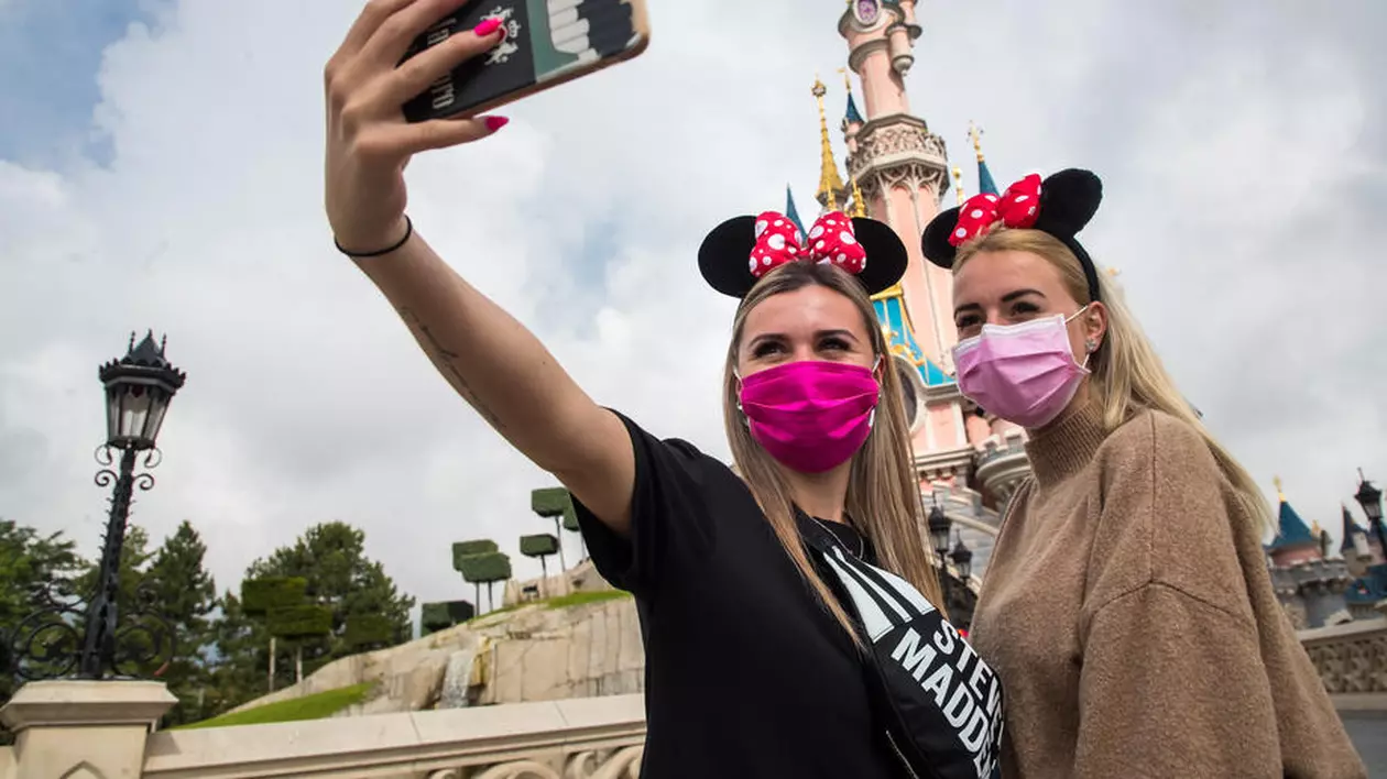 Turiști într-un parc Disney, făcându-și selfie-uri. Foto EPA