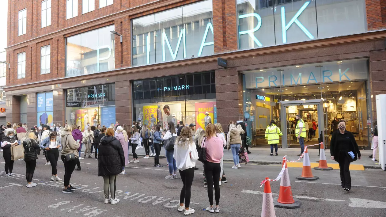 Retailerul de modă Primark vine în România. Oameni la coadă în fața unui magazin Primark, respectând distanțarea fizică