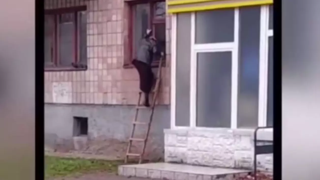 O bunicuță din Ucraina iese din bloc pe geam, cu scara, după ce la intrare a fost instalat un interfon
