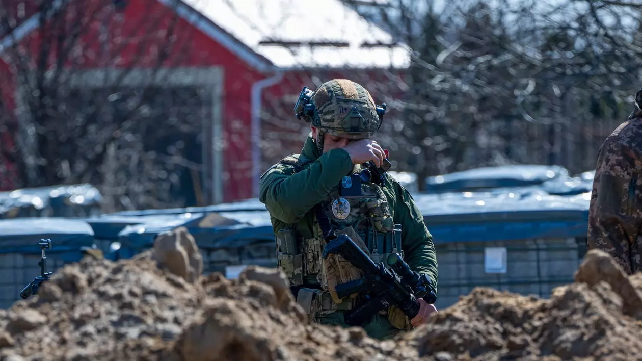 Soldat ucrainean, fotografiat plângând în fața unei gropi comune din Bucha