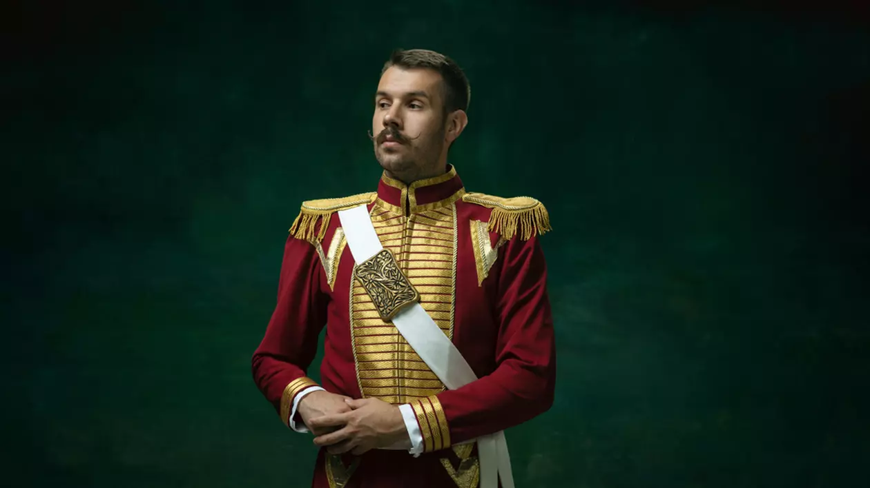 Care este diferența dintre un împărat și un rege - Imagine cu un tânăr îmbrăcat în uniformă, o ţinută şi o figură care amintesc de ţarul Nicolae al II-lea.
