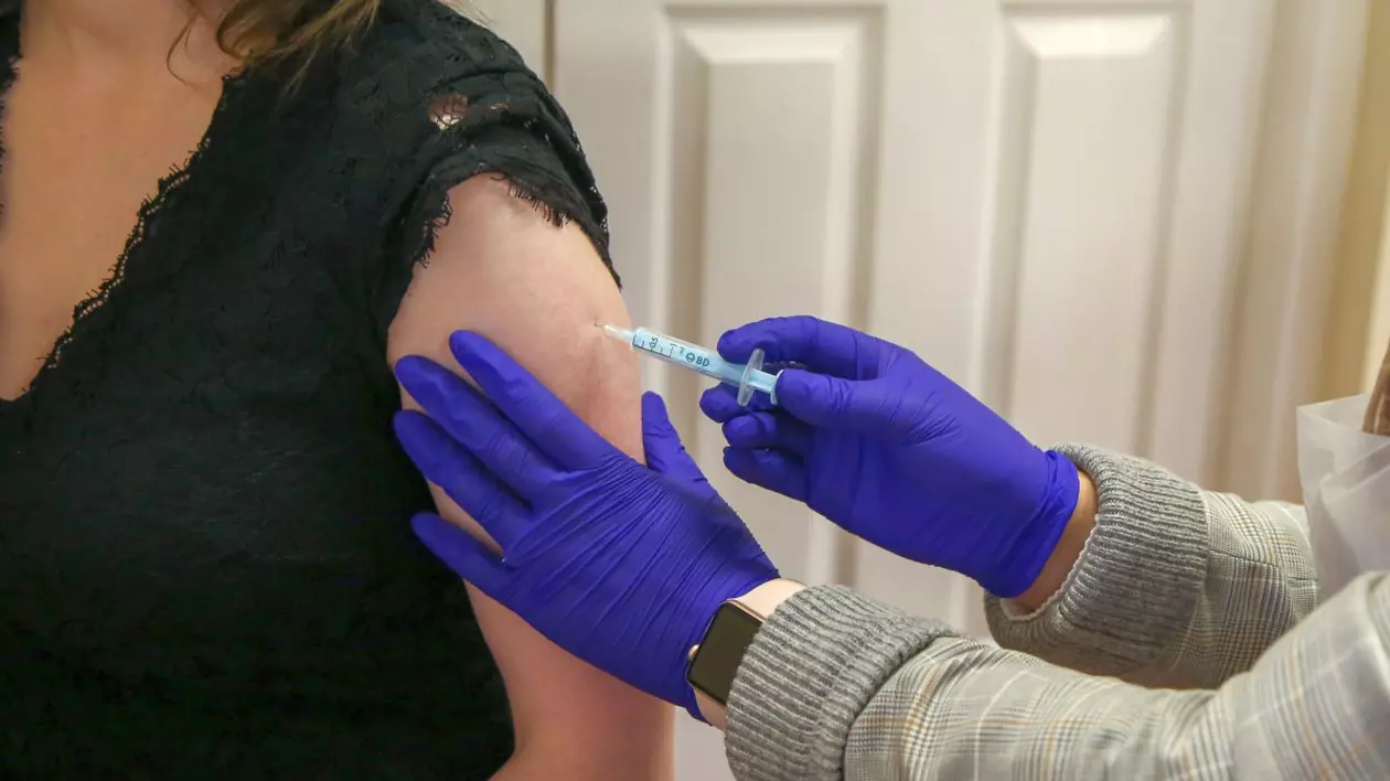 Un asistent medical administrează vaccinul Moderna anti COVID-19 la un centru de vaccinare. Foto: Hepta