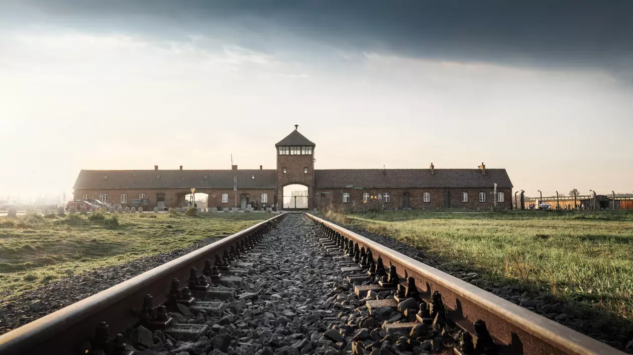 Care este originea termenului Holocaust - Imagine cu calea ferată care intră în lagărul de la Auschwitz