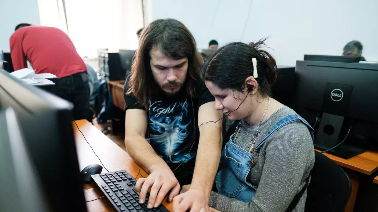 Alex, învățând o tânără nevăzătoare să folosească calculatorul, acum câțiva ani. Fotografie din arhiva AMAIS