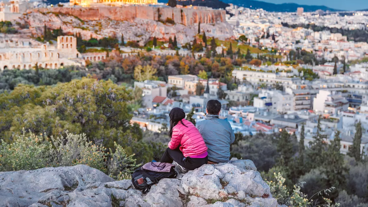 Ce poți să vizitezi în Atena - Cuplu de turişti care privesc de la înălţime către Acropole