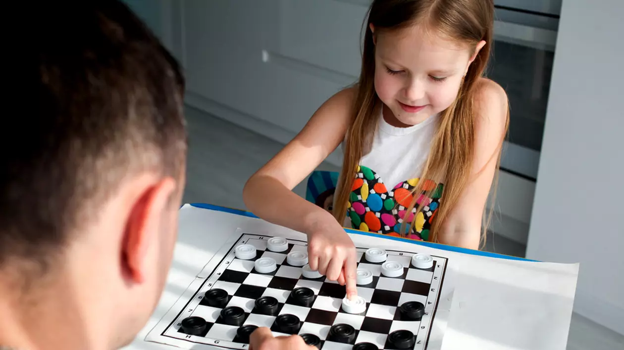 Cum se joacă Dame - Imagine cu un tată şi fiica lui jucând Dame