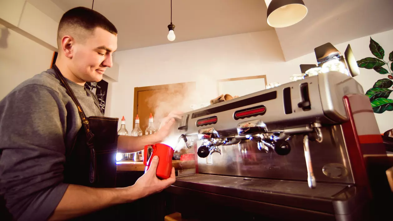 Ce este un barista și cum poți face această meserie - Imagine cu un barista care prepară o cafea într-un local