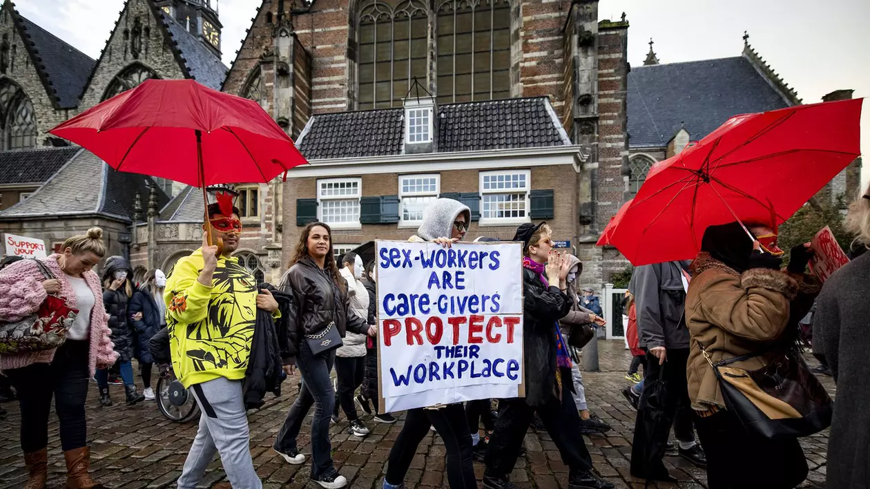 Locuitori ai Cartierului Roșu din Amsterdam, antreprenori și lucrători sexuali protestează joi, 19 octombrie, împotriva mutării bordelurilor cu vitrine într-un centru erotic din afara orașului. Foto: Profimedia