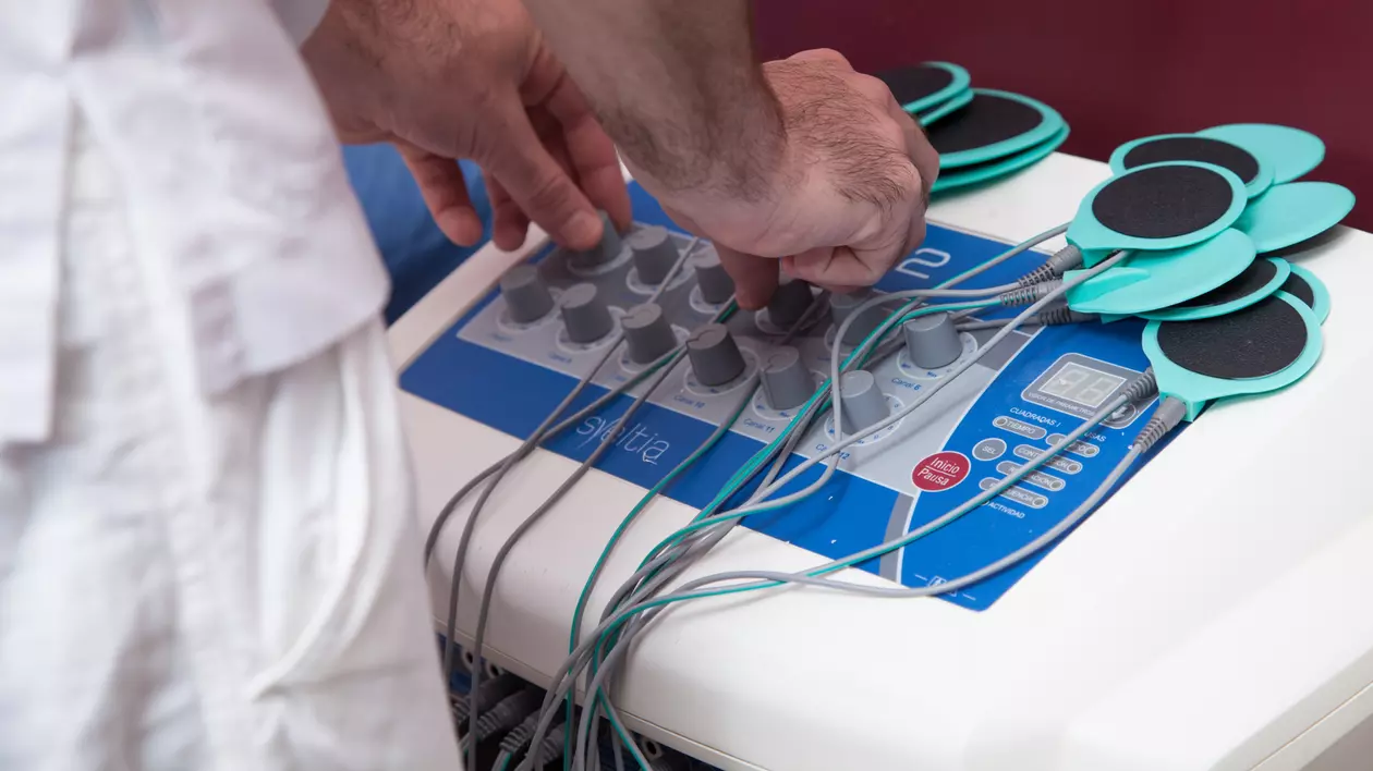 Ce este electroterapia și ce beneficii are - Imagine cu un asistent medical care operează un aparat de electroterapie